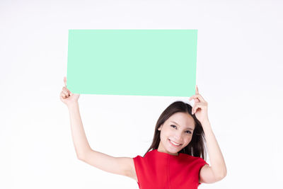Portrait of smiling young woman against white background