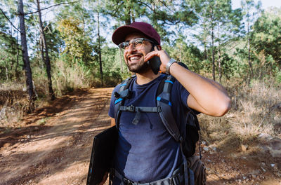 Portrait of smiling man standing in forest