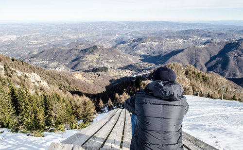 Man looking at mountains against sky