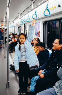 Full length of people sitting in train