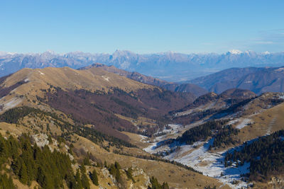 Scenic view of landscape and mountains against blue sky