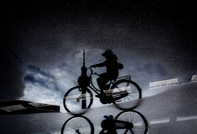 Man riding bicycle on street at night