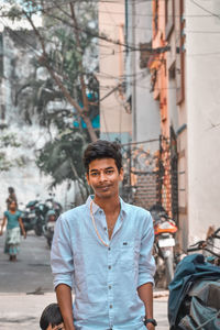 Portrait of young man standing in city