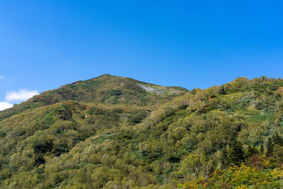 Scenic view of mountains against clear blue sky