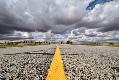 Surface level of road against cloudy sky