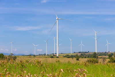 Windmills on field against sky