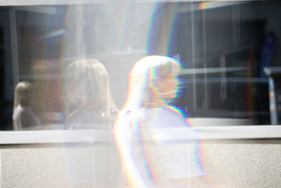 Double exposure of beautiful young woman standing in front of building