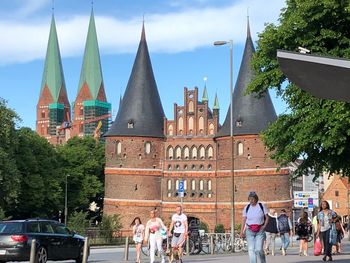 People in front of buildings against sky