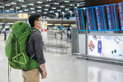 Rear view of man and woman standing at airport