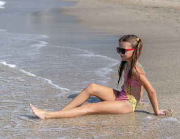 Portrait of young woman sitting on beach