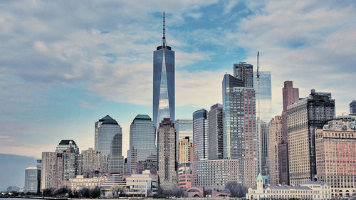 Low angle view of modern buildings against cloudy sky