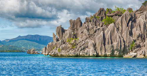 Panoramic view of rocks and sea against sky