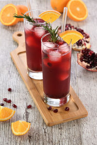 Pomegranate orange holiday punch with ice and rosemary. 