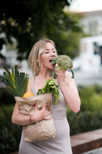 Young woman eating broccoli