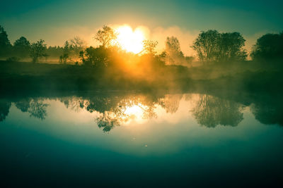 Scenic view of lake against sky during sunset