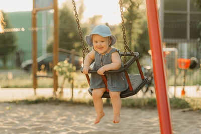 Full length of boy swinging at playground