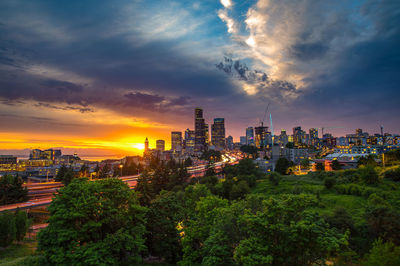 Buildings in city against sky during sunset