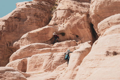 Hikers climbing on rock formation
