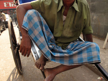 Low section of man sitting on cart