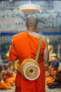 Rear view of monk standing in temple