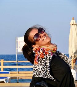 Portrait of a smiling young woman in sea against sky