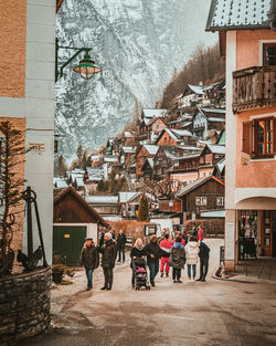 People walking on street amidst buildings in city