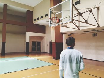 Rear view of man standing at basketball court