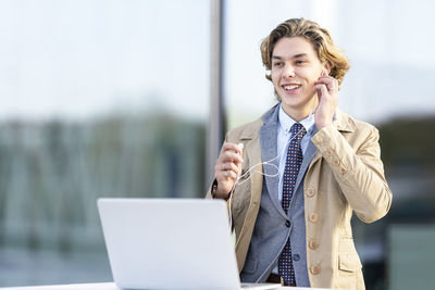 Portrait of smiling young man using mobile phone
