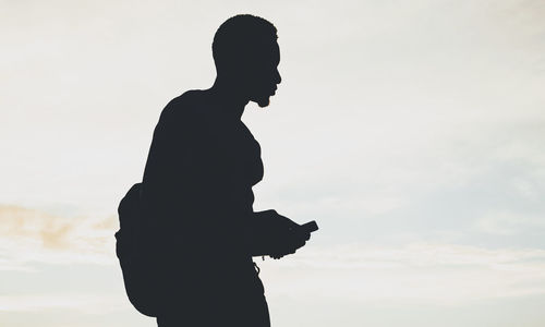 Silhouette man standing against sky