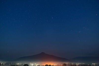 Scenic view of mountains against blue sky at night