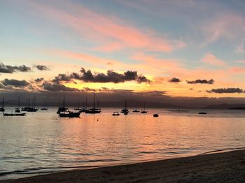 Silhouette boats moored on sea against sky during sunset