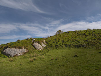 Rocks on field against sky