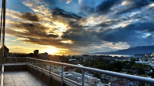 Cityscape against cloudy sky at sunset