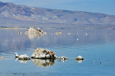 Scenic view of lake by mountains against sky