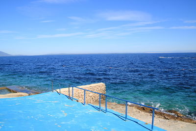 Scenic view of old pool by sea against sky