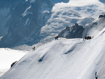 High angle view of tourists on snow covered mountain