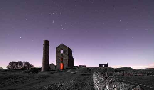 Low angle view of old ruin against clear sky at night