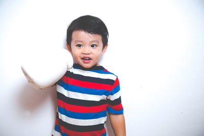 Boy wearing boxing glove against white background