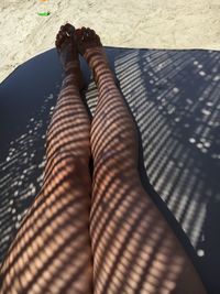 Low section of woman standing on sand