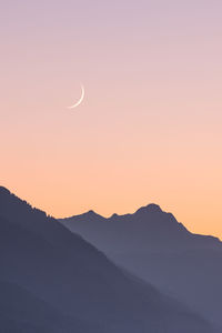 Scenic view of silhouette mountains against clear sky during sunset