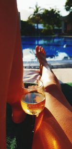 Midsection of man drinking glass at water