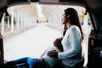 Side view of woman sitting in car