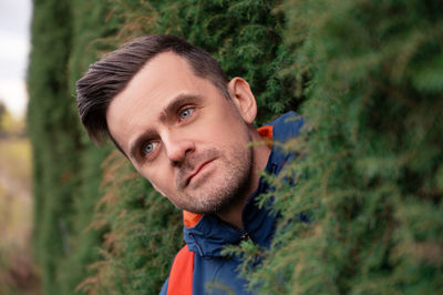 Portrait of young man against trees