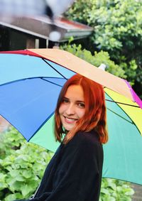 Portrait of smiling woman holding umbrella