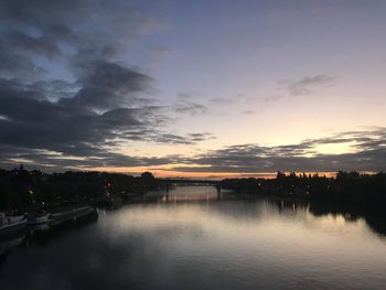 Scenic view of river against sky at sunset