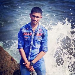 Portrait of young man standing in sea