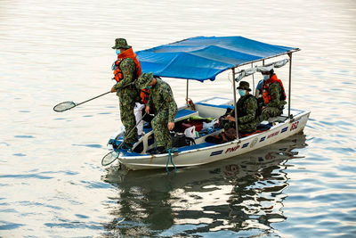 People in boat on sea during winter