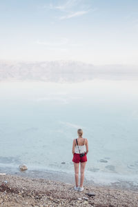 Woman standing on beach against sky