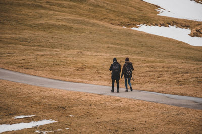 Rear view of people walking on road