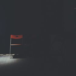Empty chair in darkroom